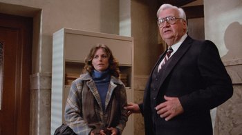 Movie still from “Gremlins” (1984), directed by Joe Dante – An older man and a younger woman standing next to each other; Medium shot, Low angle