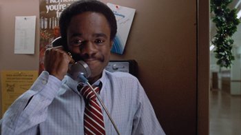 Movie still from “Gremlins” (1984), directed by Joe Dante – A man wearing a red tie talking on a phone; Close Up shot, Low angle