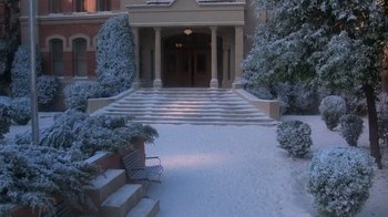 Movie still from “Gremlins” (1984), directed by Joe Dante – A bench sitting in front of an entrance to a building; Extreme Wide shot, High angle
