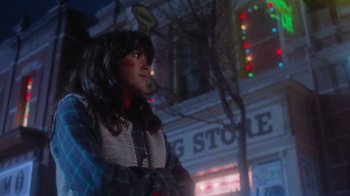 Movie still from “Gremlins” (1984), directed by Joe Dante – A woman standing in front of a building at night; Medium shot, Low angle