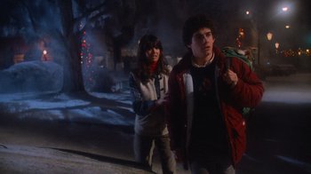 Movie still from “Gremlins” (1984), directed by Joe Dante – A man and a woman standing next to each other on a street; Medium shot, Low angle