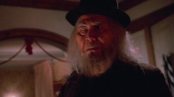 Movie still from “Gremlins” (1984), directed by Joe Dante – An old man with long white beard wearing a black hat; Close Up shot, Low angle