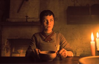Movie still from “Gretel & Hansel” (2020), directed by Oz Perkins – A person sitting at a table with a bowl of food; Medium shot, Low angle