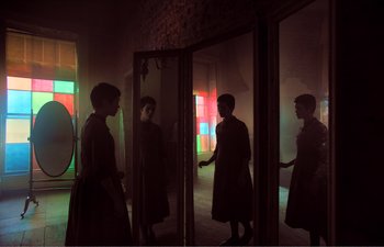 Movie still from “Gretel & Hansel” (2020), directed by Oz Perkins – A group of people standing in front of a window; Wide shot, Low angle