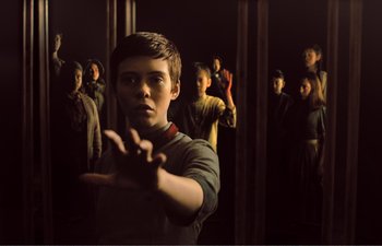 Movie still from “Gretel & Hansel” (2020), directed by Oz Perkins – A group of people standing in a dark room; Medium shot, Over the shoulder angle