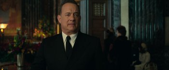 Movie still from “Greyhound” (2020), directed by Aaron Schneider – A man in a suit and tie standing in front of a building; Close Up shot, Over the shoulder angle