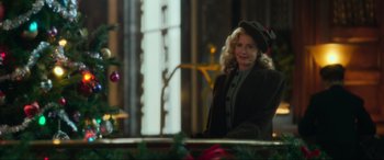 Movie still from “Greyhound” (2020), directed by Aaron Schneider – A woman wearing a hat standing in front of a christmas tree; Medium shot, Low angle