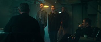 Movie still from “Greyhound” (2020), directed by Aaron Schneider – A group of men standing next to each other in a room; Medium shot, Low angle