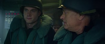 Movie still from “Greyhound” (2020), directed by Aaron Schneider – Two men in green jackets and helmets looking at each other; Close Up shot, Over the shoulder angle