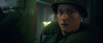 Movie still from “Greyhound” (2020), directed by Aaron Schneider – A man in a green jacket and a hat; Close Up shot, Low angle