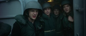 Movie still from “Greyhound” (2020), directed by Aaron Schneider – A group of men in green uniforms and helmets standing next to each other; Medium shot, Low angle