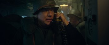 Movie still from “Greyhound” (2020), directed by Aaron Schneider – A man wearing a helmet talking on a phone; Close Up shot, High angle