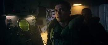 Movie still from “Greyhound” (2020), directed by Aaron Schneider – A man in a green jacket in front of a camera; Close Up shot, Low angle