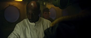 Movie still from “Greyhound” (2020), directed by Aaron Schneider – A man in a white shirt is looking at a camera; Close Up shot, Over the shoulder angle