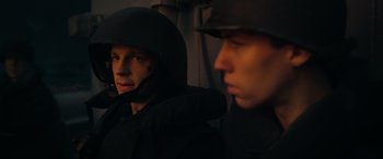 Movie still from “Greyhound” (2020), directed by Aaron Schneider – Two men in black jackets and hats are looking at the camera; Close Up shot, Over the shoulder angle