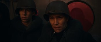 Movie still from “Greyhound” (2020), directed by Aaron Schneider – A man wearing a helmet sitting next to another man; Close Up shot, Low angle