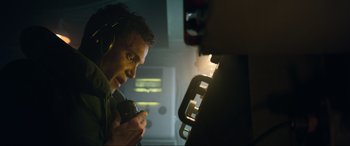 Movie still from “Greyhound” (2020), directed by Aaron Schneider – A man with headphones on looking at a monitor; Close Up shot, Low angle