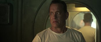 Movie still from “Greyhound” (2020), directed by Aaron Schneider – A man in a white t - shirt is looking to his left; Close Up shot, Low angle