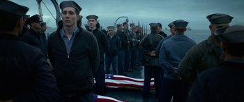 Movie still from “Greyhound” (2020), directed by Aaron Schneider – A group of men standing in front of an american flag; Medium shot, Low angle