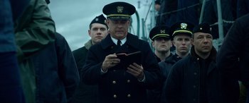 Movie still from “Greyhound” (2020), directed by Aaron Schneider – A group of men standing next to each other on a boat; Medium shot, Over the shoulder angle