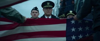Movie still from “Greyhound” (2020), directed by Aaron Schneider – A group of men standing next to an american flag; Medium shot, Low angle