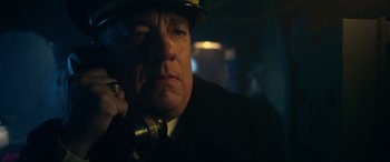 Movie still from “Greyhound” (2020), directed by Aaron Schneider – A man in a hat is talking on a phone; Close Up shot, Low angle