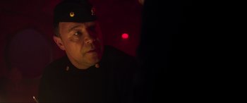 Movie still from “Greyhound” (2020), directed by Aaron Schneider – A man wearing a black uniform and a red light; Close Up shot, Over the shoulder angle
