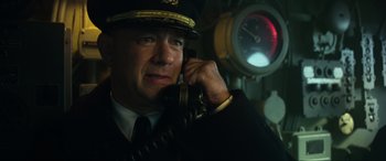 Movie still from “Greyhound” (2020), directed by Aaron Schneider – A man in a uniform talking on a phone; Close Up shot, Low angle