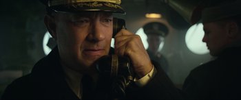 Movie still from “Greyhound” (2020), directed by Aaron Schneider – A man talking on a phone; Close Up shot, Low angle