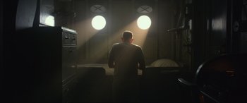 Movie still from “Greyhound” (2020), directed by Aaron Schneider – A man standing in front of a window in the dark; Wide shot, Low angle