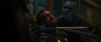 Movie still from “Guardians of the Galaxy” (2014), directed by James Gunn – A man being held down by another man holding a baseball bat; Close Up shot, Over the shoulder angle
