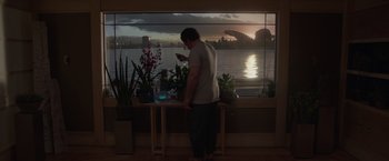 Movie still from “Guardians of the Galaxy” (2014), directed by James Gunn – A man standing in front of a window looking at his phone; Wide shot, Low angle