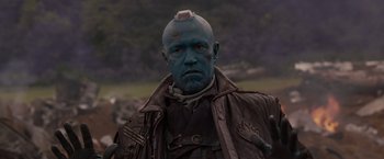 Movie still from “Guardians of the Galaxy” (2014), directed by James Gunn – A man with blue hair is standing in a field; Close Up shot, Low angle