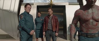 Movie still from “Guardians of the Galaxy” (2014), directed by James Gunn – A group of people standing next to each other in front of a building; Medium shot, Over the shoulder angle