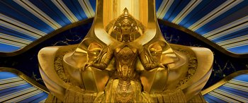 Movie still from “Guardians of the Galaxy Vol. 2” (2017), directed by James Gunn – A woman sitting on top of a chair wearing a gold costume; Wide shot, Overhead angle