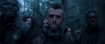 Movie still from “Guardians of the Galaxy Vol. 2” (2017), directed by James Gunn – A group of people standing in the woods with one man looking at the camera; Close Up shot, Over the shoulder angle