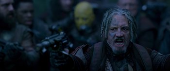 Movie still from “Guardians of the Galaxy Vol. 2” (2017), directed by James Gunn – A man with a gun in his hand and another man in a mask in the background; Close Up shot, Low angle