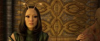 Movie still from “Guardians of the Galaxy Vol. 2” (2017), directed by James Gunn – A woman in a green shirt with a strange hairpiece; Close Up shot, Over the shoulder angle