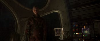 Movie still from “Guardians of the Galaxy Vol. 2” (2017), directed by James Gunn – A man standing next to a mirror in a dark room; Medium shot, Low angle