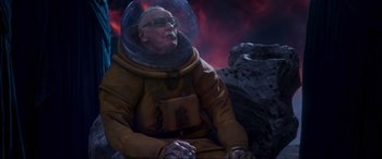 Movie still from “Guardians of the Galaxy Vol. 2” (2017), directed by James Gunn – An old man in a space suit sitting on a rock; Medium shot, Low angle