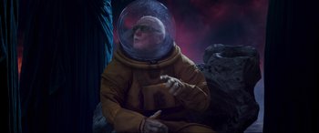 Movie still from “Guardians of the Galaxy Vol. 2” (2017), directed by James Gunn – An old man in a space suit sitting on a rock; Medium shot, Low angle