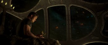 Movie still from “Guardians of the Galaxy Vol. 2” (2017), directed by James Gunn – A man sitting in a plane looking out a window; Wide shot, Over the shoulder angle