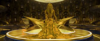 Movie still from “Guardians of the Galaxy Vol. 2” (2017), directed by James Gunn – A woman sitting on top of a large object in front of a wall; Wide shot, High angle