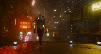 Movie still from “Guardians of the Galaxy Vol. 3” (2023), directed by James Gunn – A woman walking through a city at night with neon lights; Wide shot, Low angle