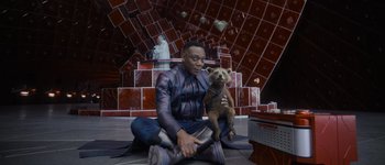 Movie still from “Guardians of the Galaxy Vol. 3” (2023), directed by James Gunn – A man holding a stuffed animal while kneeling next to him; Medium shot, Over the shoulder angle