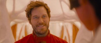 Movie still from “Guardians of the Galaxy Vol. 3” (2023), directed by James Gunn – A person wearing a red shirt smiling; Close Up shot, Over the shoulder angle