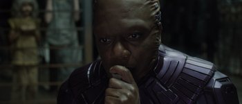 Movie still from “Guardians of the Galaxy Vol. 3” (2023), directed by James Gunn – A man in a purple suit is holding his hand to his mouth; Close Up shot, High angle