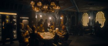 Movie still from “Guardians of the Galaxy Vol. 3” (2023), directed by James Gunn – A group of people sitting around a table in a room; Wide shot, High angle