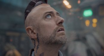 Movie still from “Guardians of the Galaxy Vol. 3” (2023), directed by James Gunn – A bald man with a tattoo on his head looking up; Close Up shot, Low angle