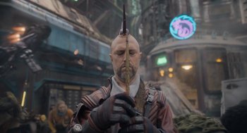 Movie still from “Guardians of the Galaxy Vol. 3” (2023), directed by James Gunn – A bald man with a mohawk haircut holding a knife; Close Up shot, Over the shoulder angle